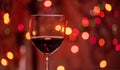 Red wine glass against christmas lights bokeh background Royalty Free Stock Photo