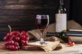 Red wine in a glass against a rustic background Alcohol, winery concept on wooden table Old and dark wooden background with Royalty Free Stock Photo