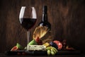 Red wine glass and appetizers, cheese, salami, figs, grapes, vintage wooden table background, selective focus, copy space