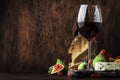 Red wine glass and appetizers, cheese, salami, figs, grapes, vintage wooden table background, selective focus, copy space Royalty Free Stock Photo