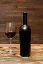 Red wine in glass, black bottle on wooden rustic table, alcohol drink, cocktail, still life copy space, dark photo, mock up Royalty Free Stock Photo