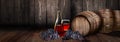 Red wine glass bottle with barrel on vineyard wood Royalty Free Stock Photo