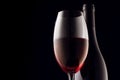 red wine, glass and bottle on a black background, close-up Royalty Free Stock Photo