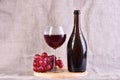 Red wine in glass and bottle with grapes on textile background