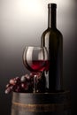 Red wine glass and bottle on wooden barrel Royalty Free Stock Photo