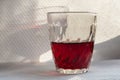 red wine in a glass Cup on a white table with a beautiful shadow