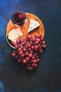 Red wine in a glass, grapes and cheese with a mold on a blue background. Top view, space for text. Royalty Free Stock Photo