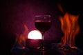 Red wine glass with light in the background and fire on the side in purple color Royalty Free Stock Photo