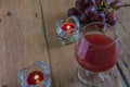 Red wine in glass for a romantic and candle on wooden table. Royalty Free Stock Photo