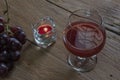 Red wine in glass for a romantic and candle on wooden table. Royalty Free Stock Photo