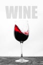 Red wine in the glass splashes in motion on a white background. Stylish design card with text Royalty Free Stock Photo