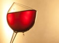 Red wine in the glass tilted with golden drop and space for text Royalty Free Stock Photo