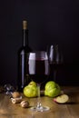 Red Wine Glasses and Bottle on Wooden Black Background Vertical Dark Ripe Fruits Apple Pears Wine Drink Royalty Free Stock Photo