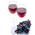 Red wine in glasses and a bunch of black grapes on a white background. Isolated composition Royalty Free Stock Photo