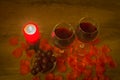 Red wine glasses, grapes, burning candle, and rose leaves on table Royalty Free Stock Photo