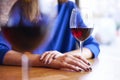 Red wine in glasses near window in cafe, chilling on vacation or holidays, bar concept. Woman hand holding a glass