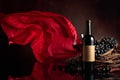 Red wine with grapes on a background of red flutters curtain Royalty Free Stock Photo