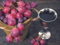 Red wine and grapes. Wine and grapes in vintage setting with corks on wooden table Royalty Free Stock Photo