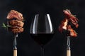 Red wine and grilled meat. Grilled pork belly and beef steak with rosemary on a black background