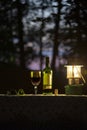 Red Wine, Lantern Light on a Picnic Table Outdoors Royalty Free Stock Photo