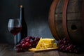 Red wine in low light with cheese and grape,wine barrel and glass