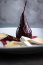 Red Wine Poached Pears in the white plate with cheese and cinnamon Royalty Free Stock Photo