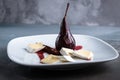 Red Wine Poached Pears in the white plate with cheese and cinnamon Royalty Free Stock Photo