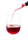 Red wine is poured through aerator into a glass with a thin stream. White background. Isolated. Close-up