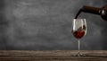 Red wine poured from a bottle into a wine glass. Blackboard background. 3D rendering