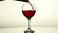 Red wine is poured from a bottle into a glass