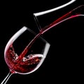 Red wine is poured into a wine glass on a black background Royalty Free Stock Photo