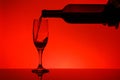 Red wine is poured into a glass from a bottle Royalty Free Stock Photo