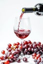 Red wine poured into glass, grapes around, isolated on white background. AI Generated Royalty Free Stock Photo