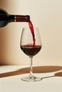 Red wine poured into glass, isolated on beige background. AI Generated Royalty Free Stock Photo