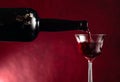 Red wine is poured from an old bottle into a crystal glass Royalty Free Stock Photo