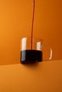 Red wine is poured in a thin stream into a glass mug