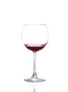 Red wine pouring from bottle into big glass on white background Royalty Free Stock Photo