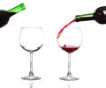 Red wine pouring from bottle into big glass on white Royalty Free Stock Photo