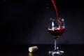 Red wine pouring from the bottle to the glass with splashes Royalty Free Stock Photo