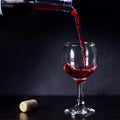 Red wine pouring from the bottle to the glass with splashes Royalty Free Stock Photo