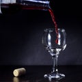 Red wine pouring from the bottle to the glass with splashes Royalty Free Stock Photo