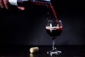 Red wine pouring from the bottle to the glass with splashes Royalty Free Stock Photo