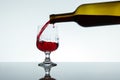 Red wine is pouring into a glass from a bottle Royalty Free Stock Photo