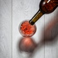 Red wine pouring into glass from bottle on white Royalty Free Stock Photo