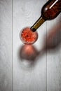 Red wine pouring into glass from bottle on white Royalty Free Stock Photo