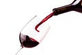 Red wine pouring in the glass on white background. Wine glass, bottle and splashes of red wine Royalty Free Stock Photo
