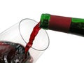 Red wine pouring from green bottle into wine glass isolated on white background Royalty Free Stock Photo