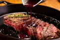 red wine reduction sauce being brushed onto sizzling steak