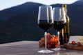 Red wine served with cheese and grapes on wooden table against mountain landscape Royalty Free Stock Photo