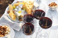 Red wine and snacks served for picnic on wooden table outdoors Royalty Free Stock Photo